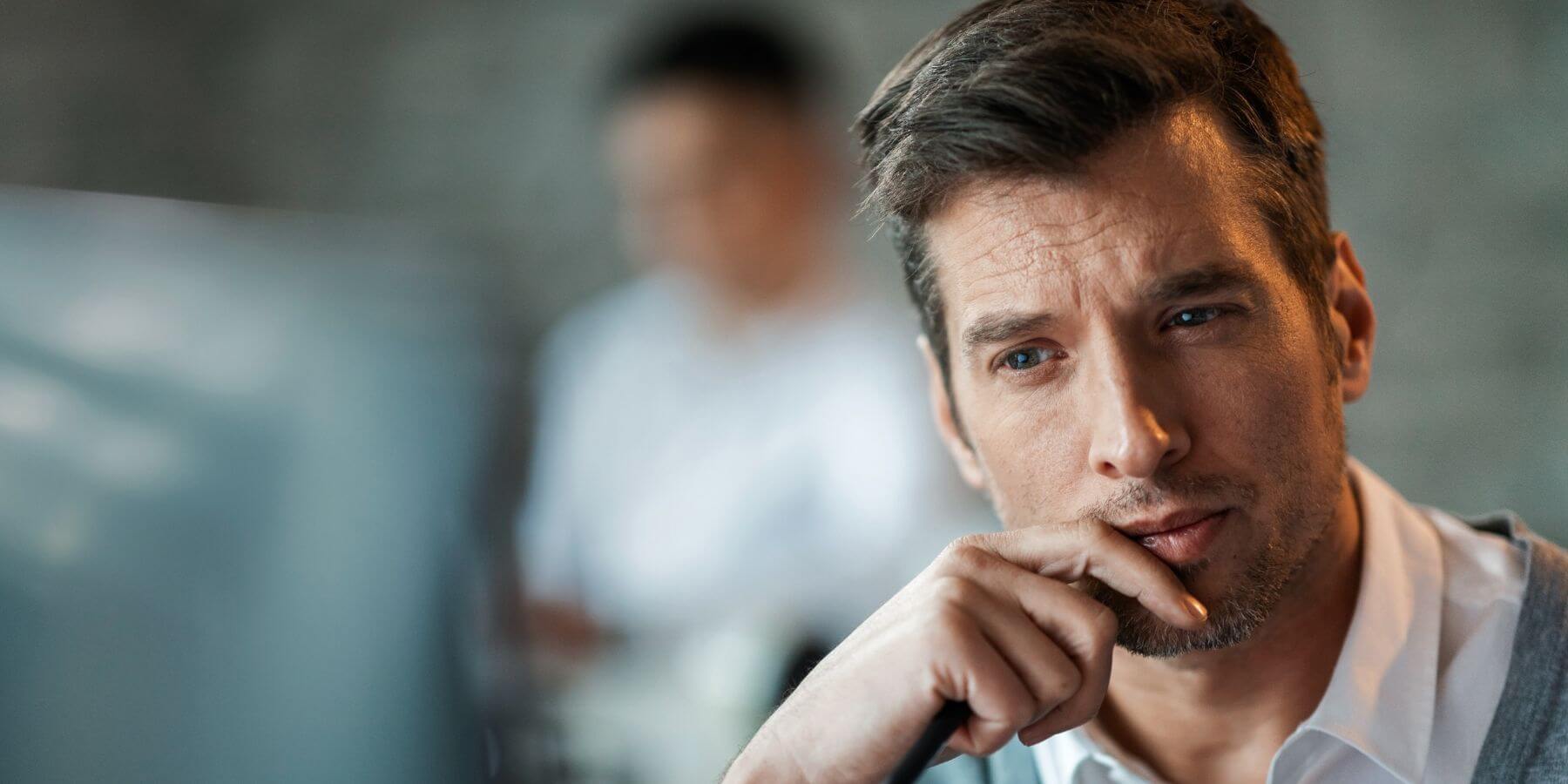 Businessman looking contemplatively at his computer screen.